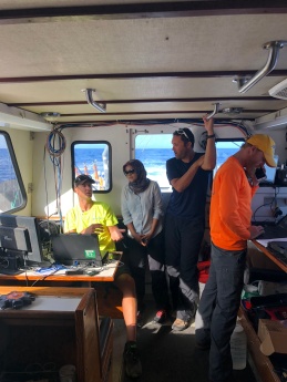 Jason, Khaira, and Eric are discussing ​water column​ Multi-beam data, whereas Patrick is operating​ the G-882 magnetometer​ system.